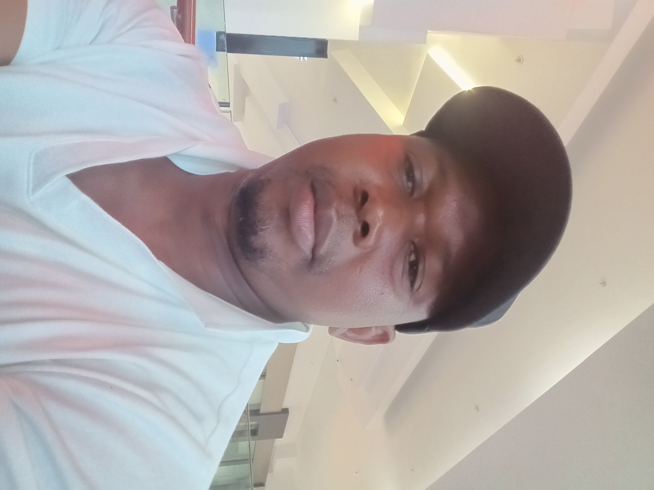 Sango working at a desk wearing a cap